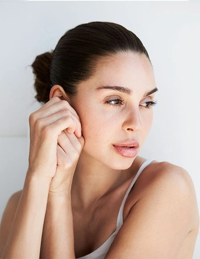 Woman with clear skin touching face demonstrating skincare routine and natural beauty - Zaffiro in Wayne, PA