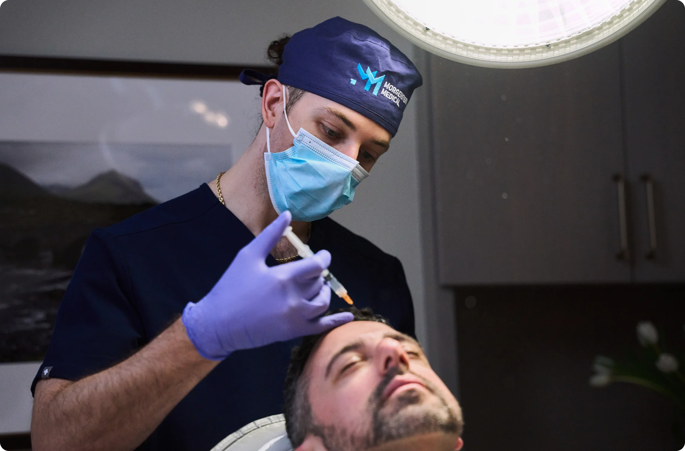 Doctor wearing protective mask and gloves while injecting product into patients hairline. - in Wayne, PA