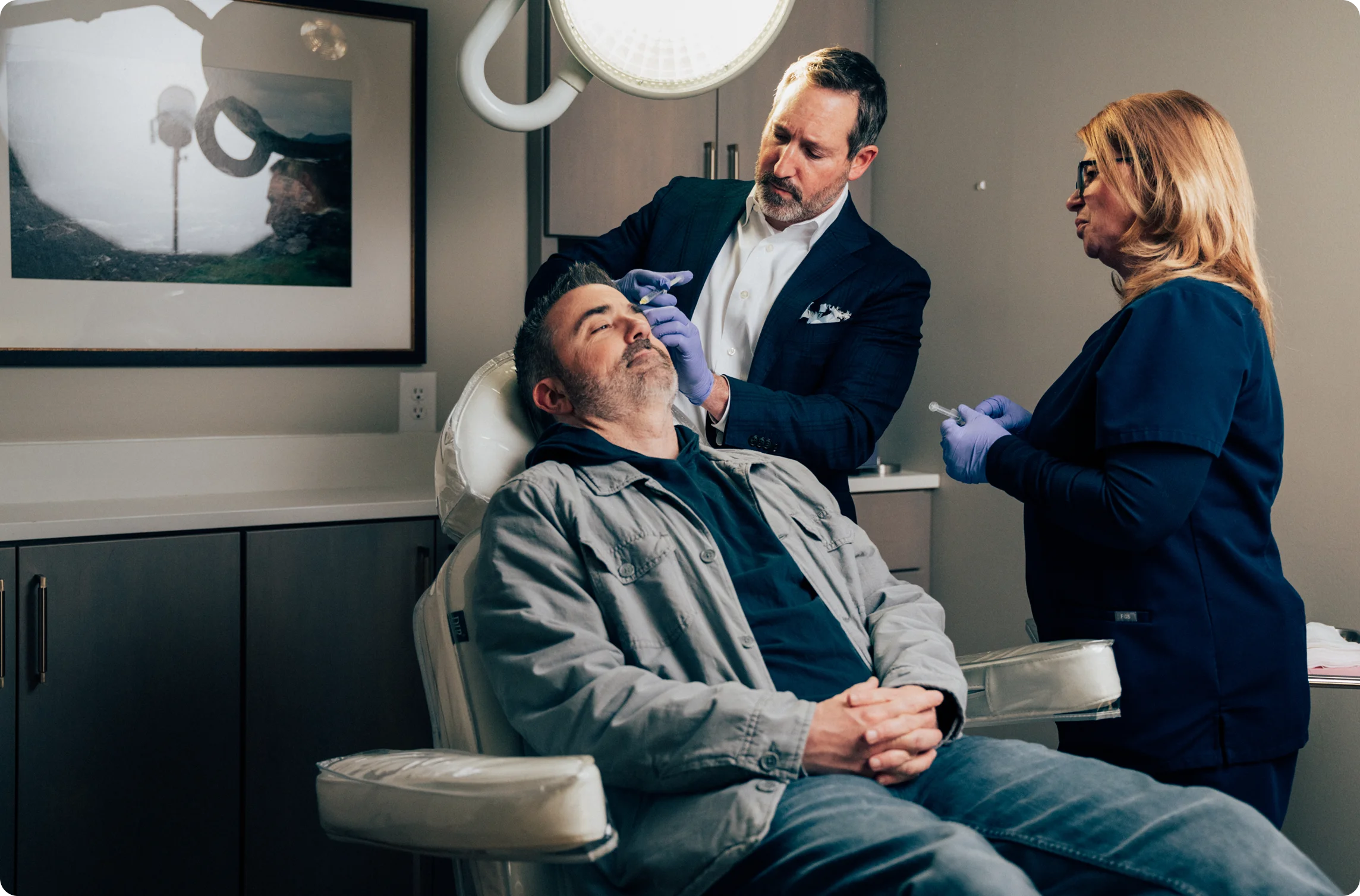 Patient relaxing in medical chair while Doctor Morganstern MD and nurse inject products into the patients face. - in Wayne, PA