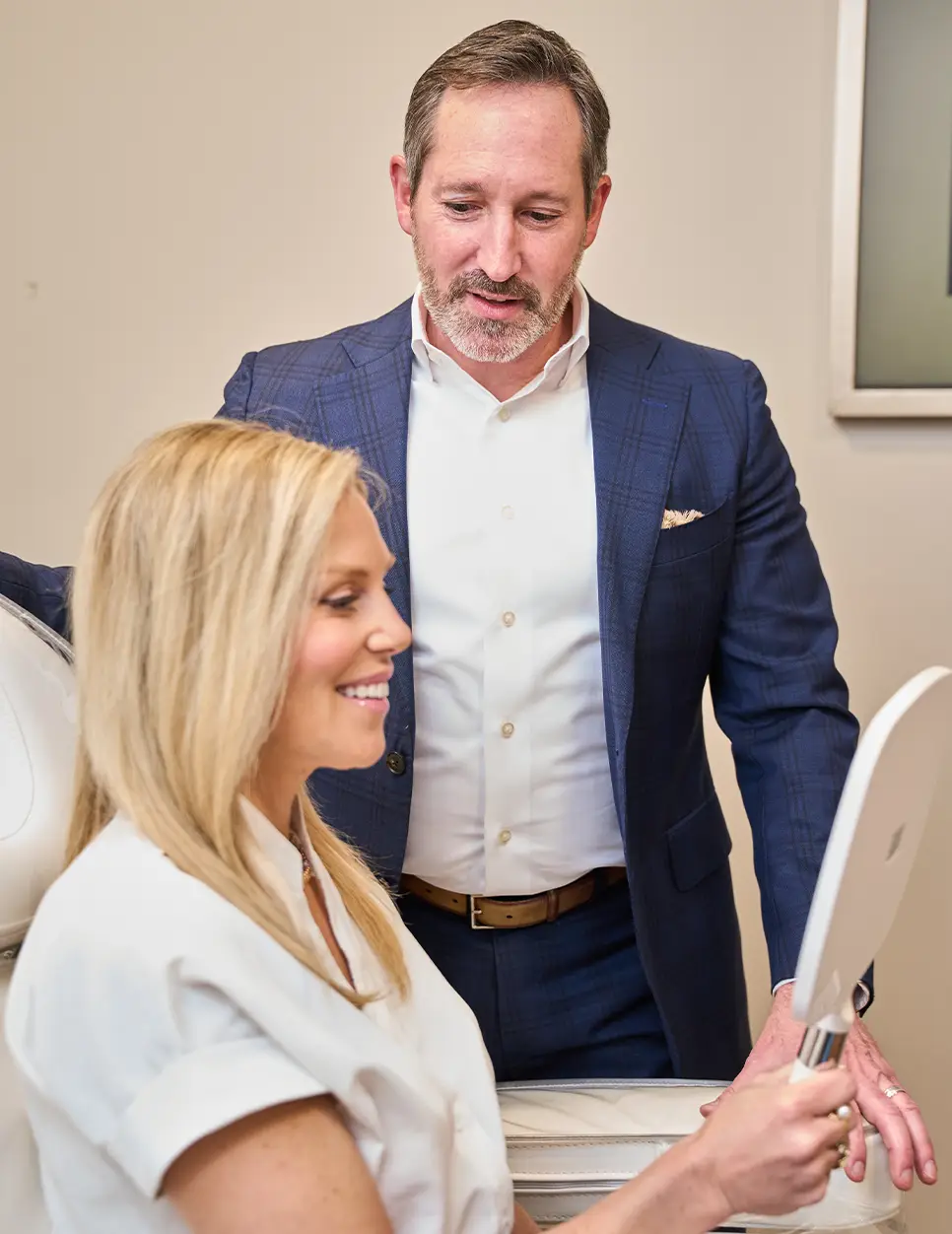 Woman consulting with hair restoration specialist Dr Ken Morganstern reviewing treatment options on tablet - in Philadelphia ,PA