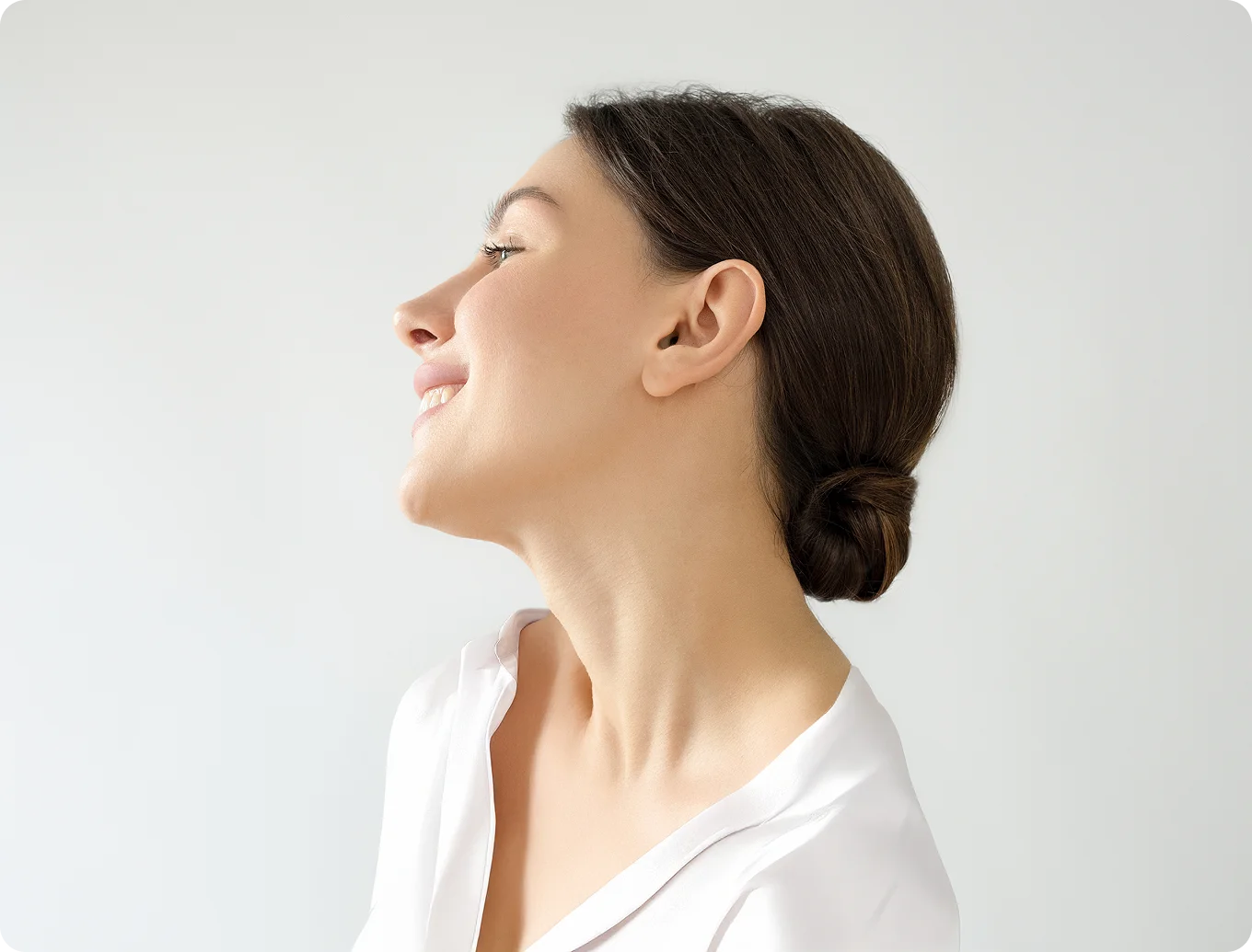 Woman in white shirt touching neck while tilting head back with closed eyes in profile view - Face in Wayne, PA