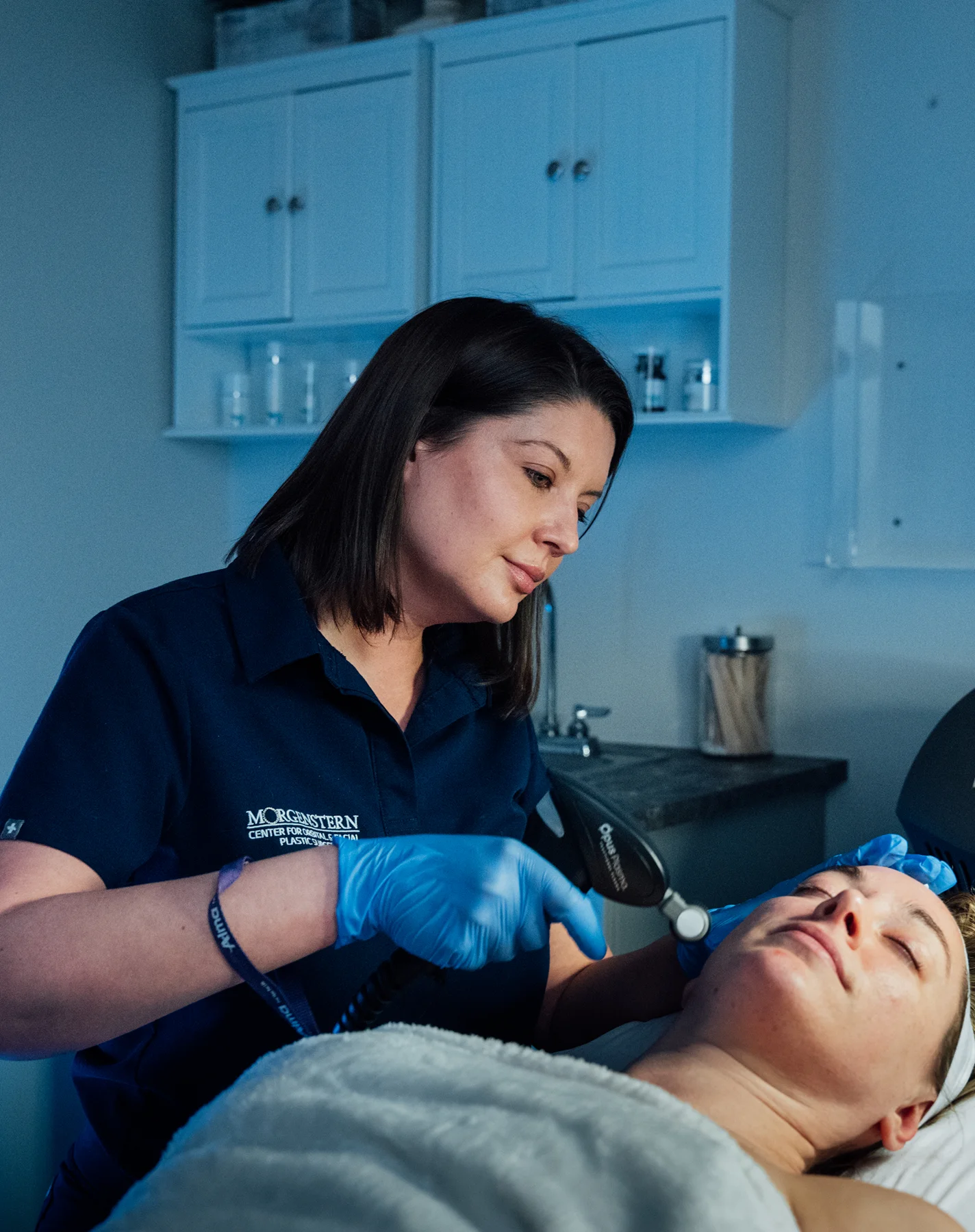 Professional performing facial treatment on client in modern aesthetic clinic with blue gloves - Skin in Wayne, PA